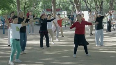 Pekin, Çin - 14 Eylül 2024 Yaşlılar parkta dans, tai chi, flüt çalma, kılıç dansı, Yangge dansı, yürüyüş, yürüyüş, spor için egzersiz yapıyorlar.