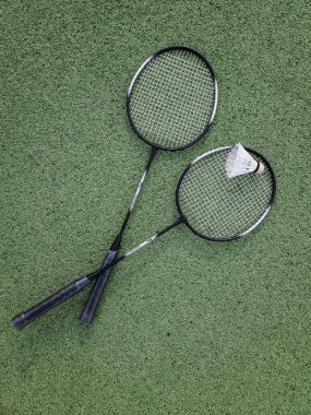 Yumuşak yeşil spor sahasında iki badminton raketi. Yüksek kalite fotoğraf