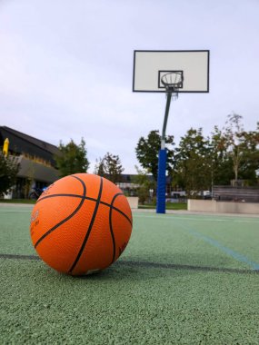 Açık hava yeşil spor sahasında turuncu basketbol, arka basketbol potası. Yüksek kalite fotoğraf