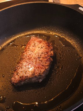 Elektrikli soba tepsisiyle biftek kızartıyorum. Yüksek kalite fotoğraf