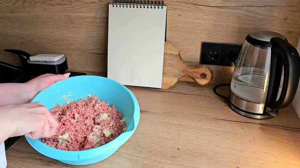 Eller et ve malzemeleri mutfak tezgahında mavi bir kasede karıştırır.. 