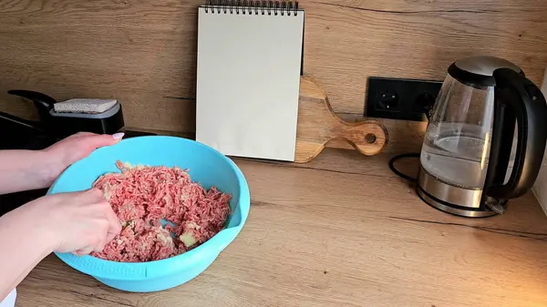 Eller et ve malzemeleri mutfak tezgahında mavi bir kasede karıştırır.. 