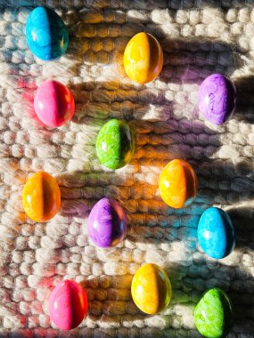 Parlak renkli Paskalya yumurtaları güneş ışığında yün halıda. Canlı bir bahar tatili arkaplanı. Yüksek kalite fotoğraf