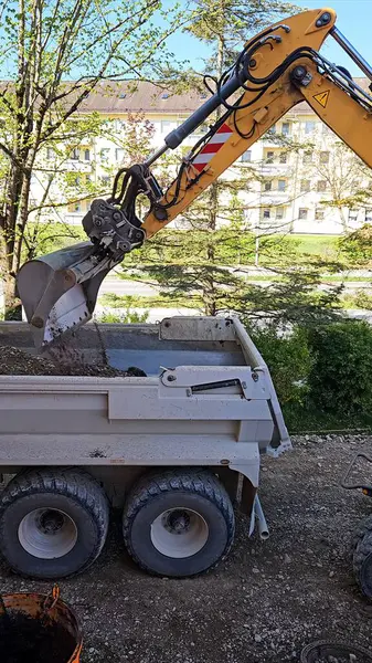 Kazıcı Çöp Kamyonu Yükleme: Toprak Taşıyıcı İnşaat Alanı. Yüksek kalite fotoğraf
