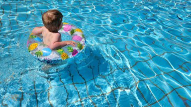 Havuzda yüzen sarışın bebeğin arka manzarası. Ananas yüzme yüzüğü. Yaz havası ve kaygısız bir tatil. Yüksek kalite fotoğraf