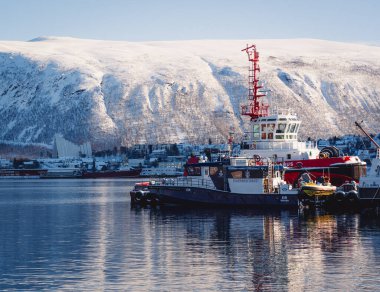 Norveç 'in Trom Limanı' ndaki gemiler, kışın. Arkaplanda, Arktik Katedral de dahil olmak üzere Trom şehir manzarası yer almaktadır..