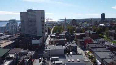 Halifax 'ta güneşli bir sonbahar günü, İHA görüntüleri şehir merkezinde yükseliyor, binaları yakalıyor ve uzaktaki liman ve okyanusu gösteriyor. Yüksek kalite 4K görüntü.