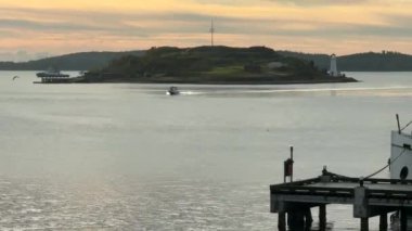 Halifax, Nova Scotia 'da gün doğumunda boğazın ortasındaki bir adanın sinematik görüntüleri. Güzel gökyüzü bir gemi ve gemi geçerken aydınlanır. Yüksek kaliteli 4K görüntülerde yakalandı..