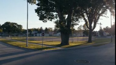 Güzel, sıcak bir yaz akşamında küçük bir Amerikan kasabasında boş bir beyzbol sahası. Çarpıcı günbatımı altın bir ışık saçarken, dur işareti olan boş bir cadde huzur dolu manzaraya ekleniyor.