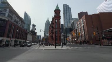 Tarihi Gooderham Binası ile modern Toronto gökdelenleri arasındaki zıtlığı gösteren çarpıcı bir 4K çekimi. Sahne açık mavi bir gökyüzüne ayarlandı, güneşli bir gün seçimiyle