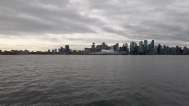 Vancouver şehrinin 4K panoramik görüntüsü, feribot metropol 'e yaklaşırken çekildi. Görüntülerde gökdelenler ve modern mimari ile şehir ufuk çizgisi sergileniyor.
