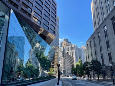 Boston 'un gökdelenlerini açık mavi gökyüzünün altında yansıtan modern bir cam bina