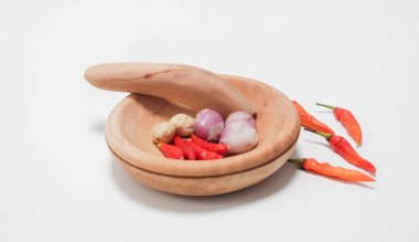 Temel yemek pişirme baharatları. Salyangozlar, kırmızı biberler ve ahşap bir havanda mumlar. beyaz arkaplanda.