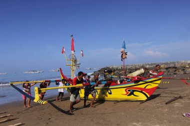 Bir grup insan sahilde bir teknede.