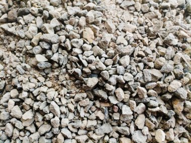 Boyut ve şekil olarak değişen karışık çakıl ve taş yığını sert bir doku oluşturur. Topraksı tonlar ve kaba yüzey, doğal ve işlenmemiş durumlarını vurguluyor. İnşaat için ideal..