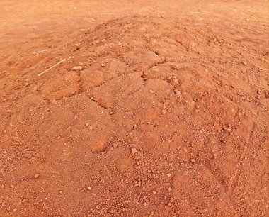 Kırmızımsı kuru, dokulu toprak yığını kabaca tahıllar ve toprak desenleri yüzeye yayılmış engebeli bir doğal manzara yaratır..
