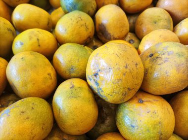 Bu lezzetli, sulu narenciye meyvesinin tazeliğini ve zengin renklerini gözler önüne seren, doğal benekleri ve işaretleri olan canlı, altın portakal yığını..