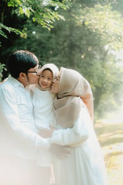 Sevgi ve sıcaklıkla dolup taşan şefkatli bir aile anı. Anne babalar, çocuklarını öpücüklere boğarken. Huzurlu doğal güzelliklerle çevrili..