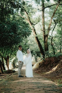 Huzurlu bir aşk ve beklenti anı huzurlu bir orman yolunda, hayatın güzelliğini ve ebeveynliğin yolculuğunu kutlayan bir çift tarafından paylaşılan..