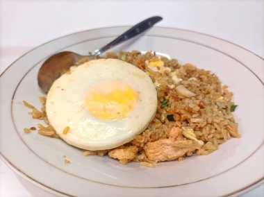 Üzerine mükemmel pişmiş, güneşli bir yumurta ve leziz bir lezzet ve dokuların ahengi konmuş bir tabak leziz kızarmış pirinç..