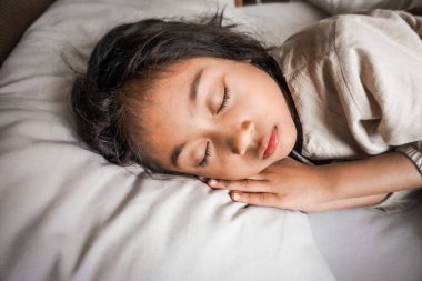 A serene portrait of a child peacefully sleeping, capturing a moment of innocence, calm, and pure relaxation in a warm and cozy ambiance. clipart