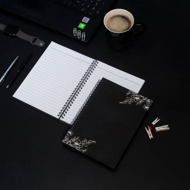 Kahve fincanı, spiral defter, bilgisayar klavyesi, saat ve kalem. 