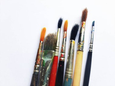 Beyaz arkaplanda suluboya fırçalar ve boyalar