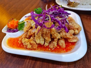 Beyaz tabakta Tayland soslu kızarmış tavuk.