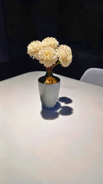 Yemek masasında çiçekler olan vazo.