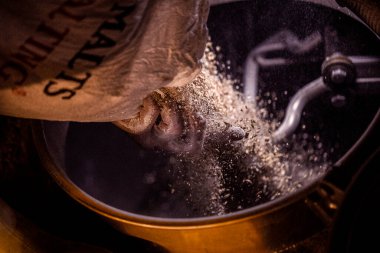 Bira üretim sürecinde bira fıçısına malt arpası dökülüyor.
