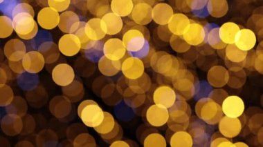 Güzel, enerjik, soyut bir arka plan. Bulanık altın bokeh ışıkları, neşeli bir ortam yaratıyor.