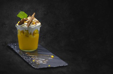 Bu tatlı, üzerinde krem şanti ve güzel bir son için taze nane yaprakları olan canlı bir mango aroması içeriyor.