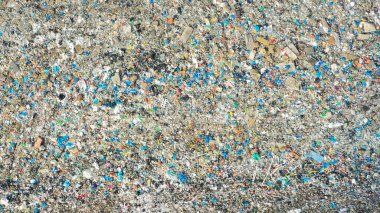 Kuma gömülü mikro plastiklerin yakın plan görüntüsü, karşılaştığımız ciddi çevresel zorlukları vurguluyor.