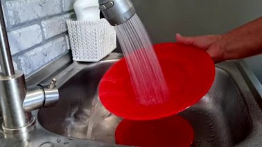 Modern bir mutfakta lavaboda kırmızı sabun yıkamak.