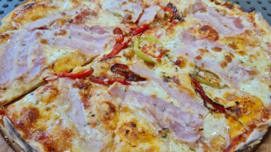 Jambonlu, peynirli, biberli, domatesli, biberli, soğanlı, sarımsaklı pizza..