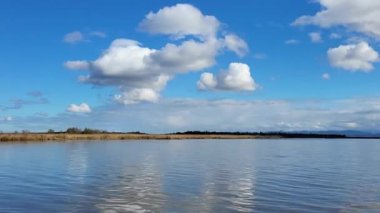 Gölü ve mavi gökyüzü olan güzel bir manzara.