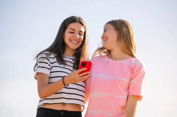 ２人の若い女の子がスマートフォンを使って — ストック写真