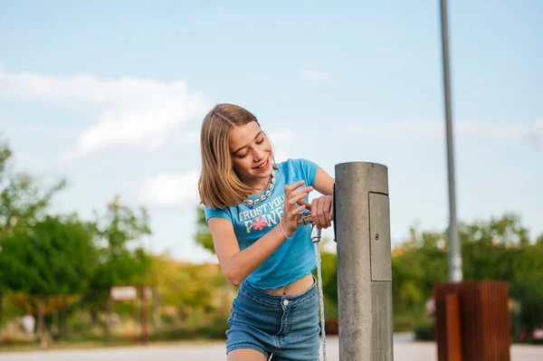 市の公園の噴水で水を飲む非常に幸せな女の子 — ストック写真