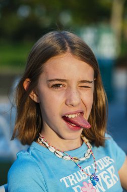 Kız kameraya bakarak dilini gösteriyor..