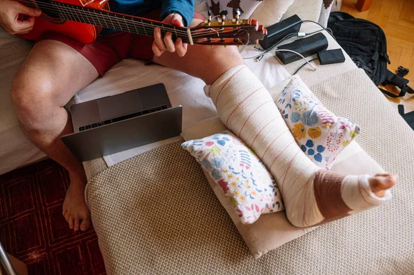 Τραυματίας Άνθρωπος Δεμένο Πόδι Και Μάθουν Παίζουν Κιθάρα Απευθείας Σύνδεση — Φωτογραφία Αρχείου