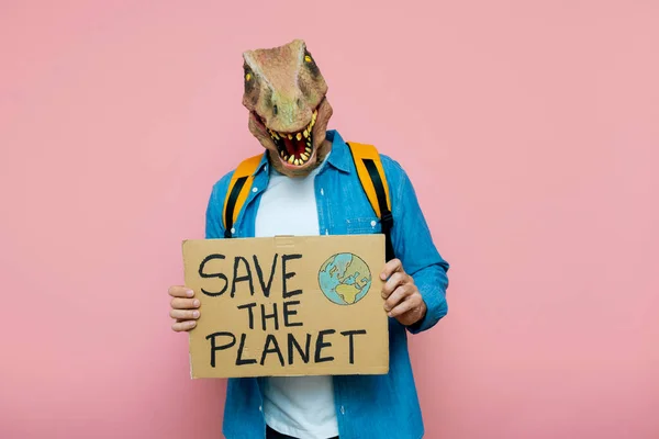 Man Backpack Lizard Mask Pink Background Holds Sign Planet — Stock Photo, Image