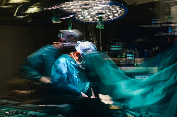 Photographic double exposure of the doctors working in the operating room.