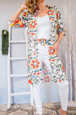 Giysilerini gösteren bir kadın ikinci el giyim sitesinde satmak istiyor..