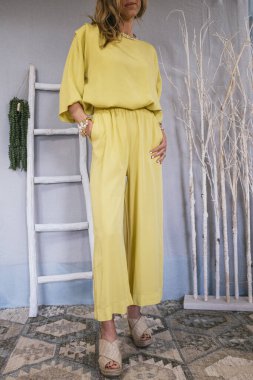 Giysilerini gösteren bir kadın ikinci el giyim sitesinde satmak istiyor..