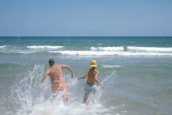 少男少女和一个成年男子在海滩享受着美好的一天 — 图库照片
