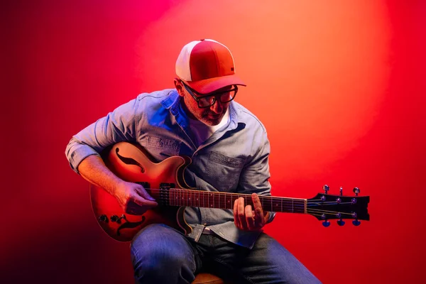 Hombre Tocando Guitarra Eléctrica Sobre Fondo Rojo —  Fotos de Stock