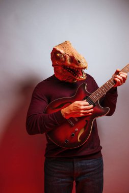 Stüdyoda kertenkele kafalı ve elektro gitarlı bir adam var..