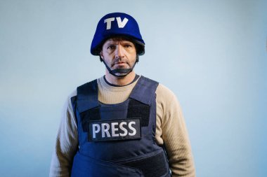 Stüdyoda kurşun geçirmez yelek giyen bir gazeteci var..