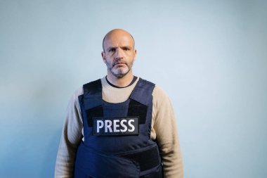 Stüdyoda kurşun geçirmez yelek giyen bir gazeteci var..