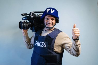 Elinde video kamera tutan kurşun geçirmez yelek giyen bir muhabir.